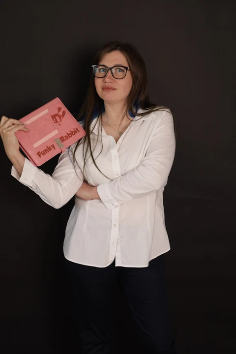 Mariia Reznichenko, founder and lead designer of Funky Rabbit, holding the Funky Rabbit brand book